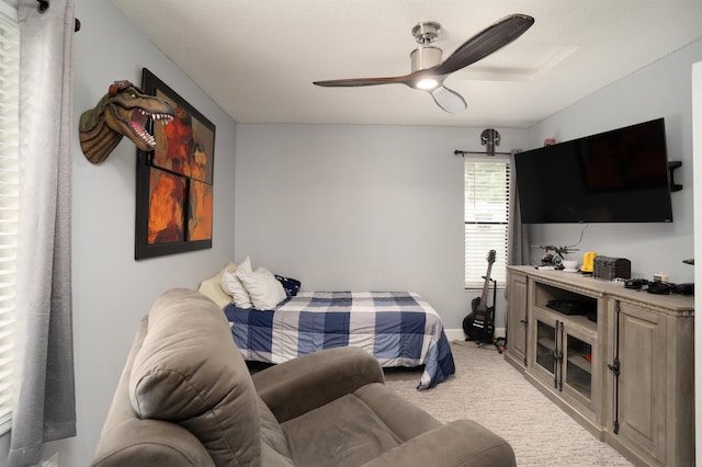 bedroom featuring light colored carpet, ceiling fan, and baseboards