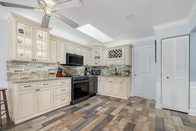 kitchen featuring cream cabinets, electric range, a sink, decorative backsplash, and crown molding