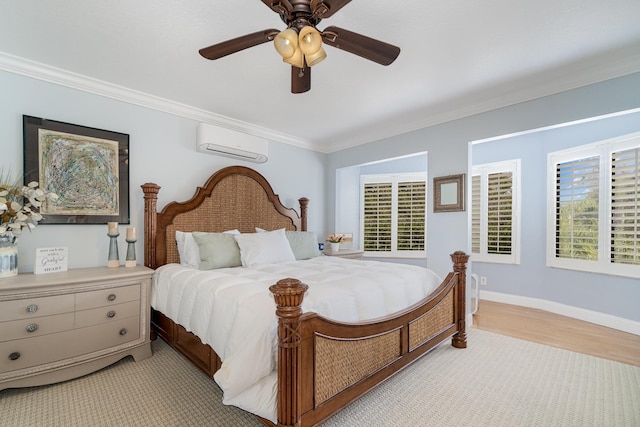 bedroom with a wall unit AC, light wood-style flooring, a ceiling fan, baseboards, and ornamental molding