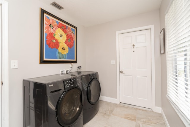 washroom with laundry area, washing machine and dryer, visible vents, and baseboards