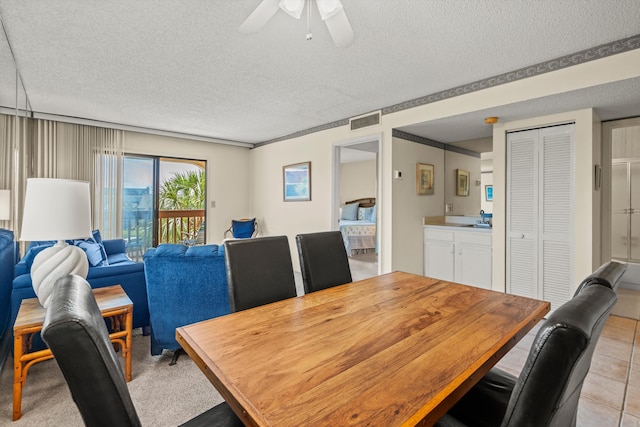 dining room featuring a textured ceiling, light tile patterned flooring, a ceiling fan, and visible vents