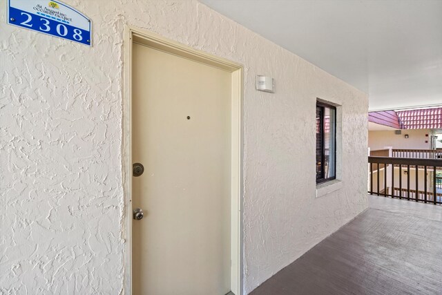 doorway to property featuring stucco siding