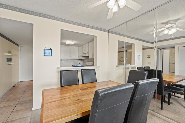 dining room featuring a textured ceiling, a ceiling fan, and light tile patterned flooring