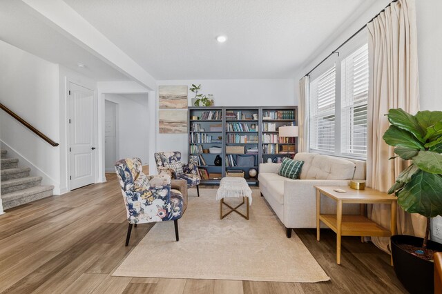 living area with stairway, wood finished floors, recessed lighting, and baseboards