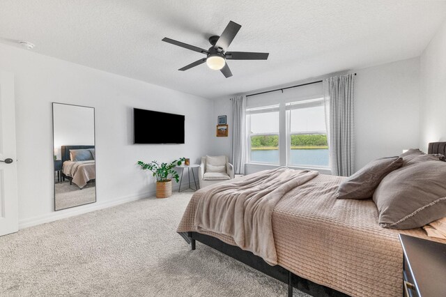 bedroom featuring carpet flooring, a ceiling fan, a textured ceiling, and baseboards