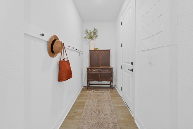 entryway with light wood-style flooring and baseboards