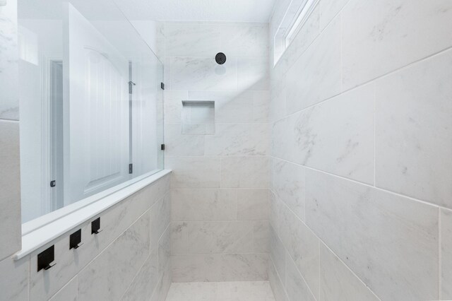 full bath featuring tiled shower