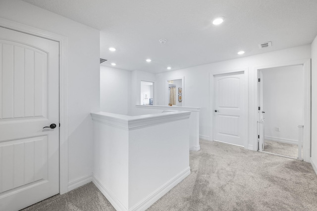 hall featuring light carpet, recessed lighting, an upstairs landing, and baseboards