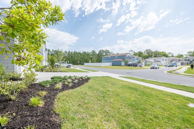 view of grassy yard with a residential view