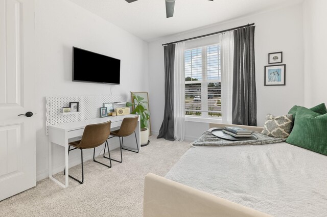 carpeted bedroom with a desk, baseboards, and ceiling fan
