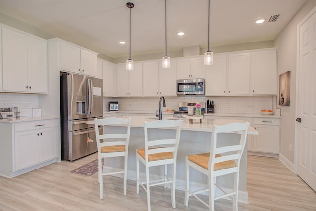 24 Pepperpike Way, Saint Augustine, FL 32092 - kitchen featuring stainless steel appliances, light countertops, decorative backsplash, white cabinets, and a breakfast bar