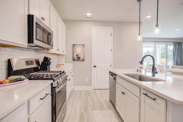 24 Pepperpike Way, Saint Augustine, FL 32092 - kitchen featuring stainless steel appliances, a sink, white cabinets, decorative backsplash, and light countertops