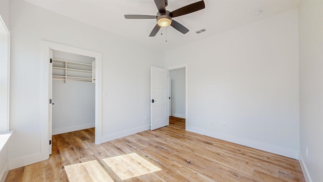 unfurnished bedroom with ceiling fan, light wood-type flooring, and a closet