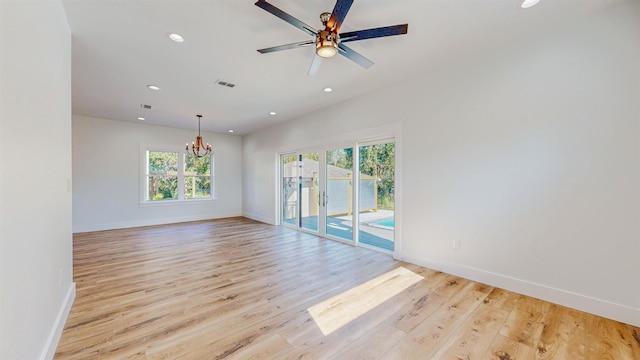 unfurnished room featuring ceiling fan with notable chandelier and light hardwood / wood-style floors