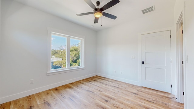 empty room with ceiling fan and light hardwood / wood-style flooring