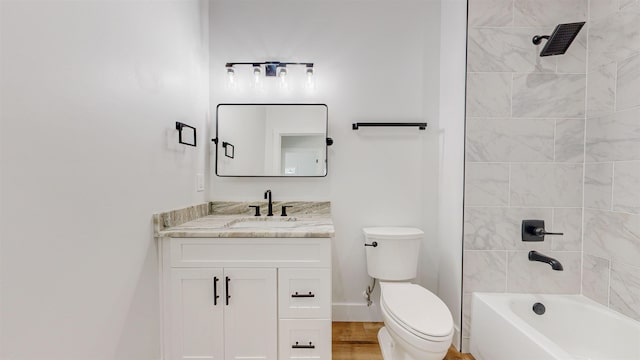 full bathroom with tiled shower / bath, hardwood / wood-style floors, vanity, and toilet