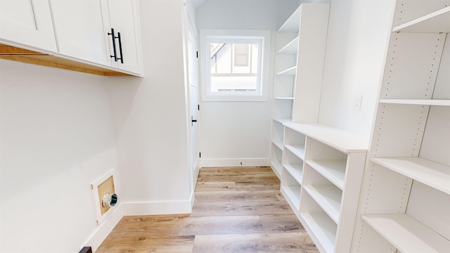 laundry area with cabinets and light wood-type flooring