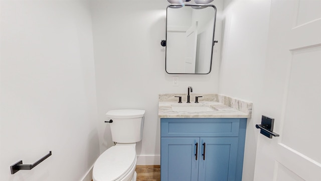 bathroom featuring vanity, hardwood / wood-style flooring, and toilet