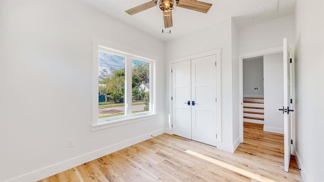 unfurnished bedroom featuring ceiling fan, a closet, and light wood-type flooring