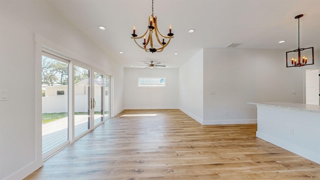 interior space with ceiling fan with notable chandelier and light hardwood / wood-style floors