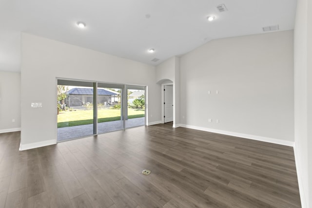 spare room with dark hardwood / wood-style flooring and vaulted ceiling