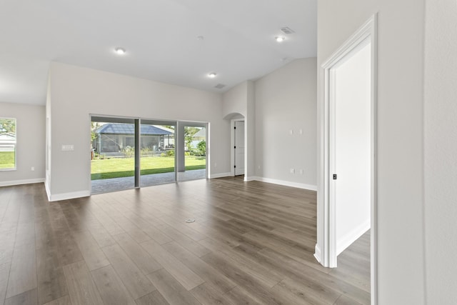 spare room featuring vaulted ceiling, golf simulator, and wood-type flooring