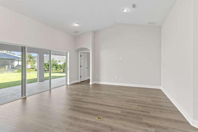 empty room with lofted ceiling and hardwood / wood-style flooring