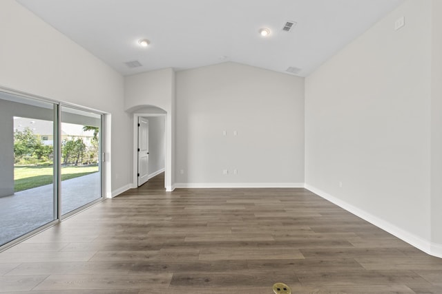 unfurnished room with high vaulted ceiling and dark wood-type flooring