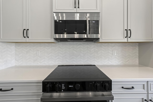 kitchen with white cabinetry, appliances with stainless steel finishes, and tasteful backsplash