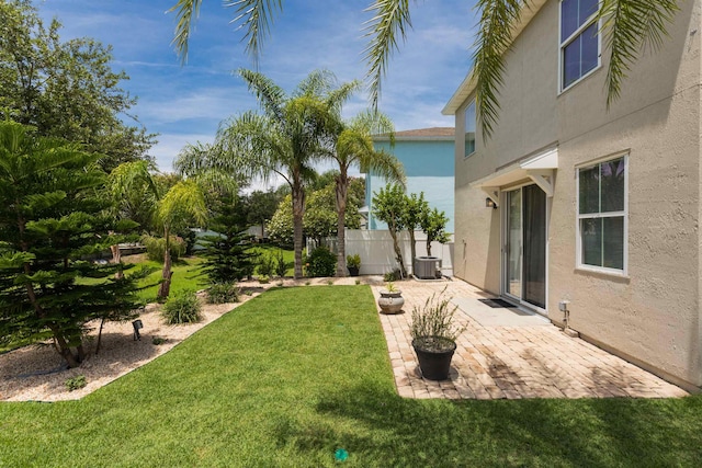 view of yard featuring a patio area, fence, and central AC