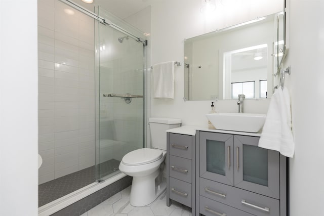 bathroom featuring toilet, a stall shower, tile patterned floors, and vanity