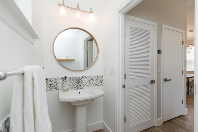 bathroom with visible vents, decorative backsplash, and wood finished floors