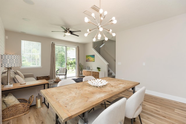 dining room featuring a ceiling fan, light wood-style flooring, baseboards, and stairs