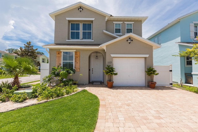 view of front of home featuring a garage, decorative driveway, and stucco siding