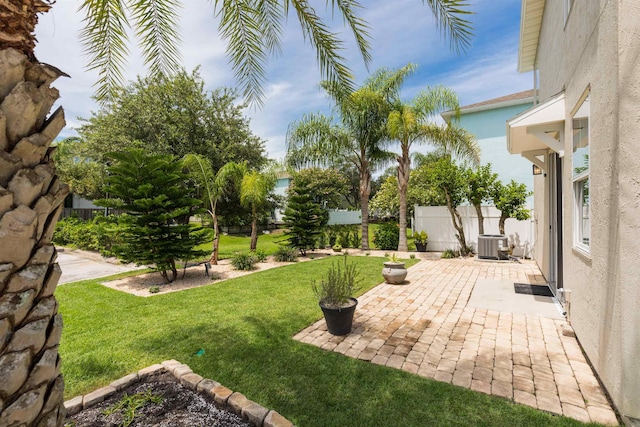 view of yard with a patio, central AC unit, and fence