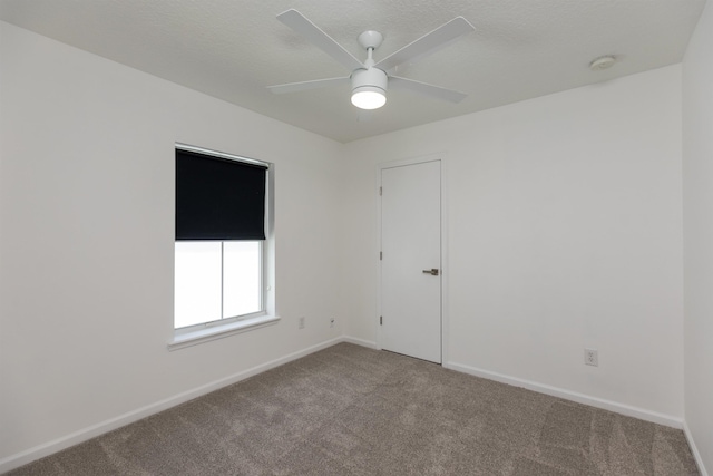 unfurnished room featuring carpet, baseboards, ceiling fan, and a textured ceiling