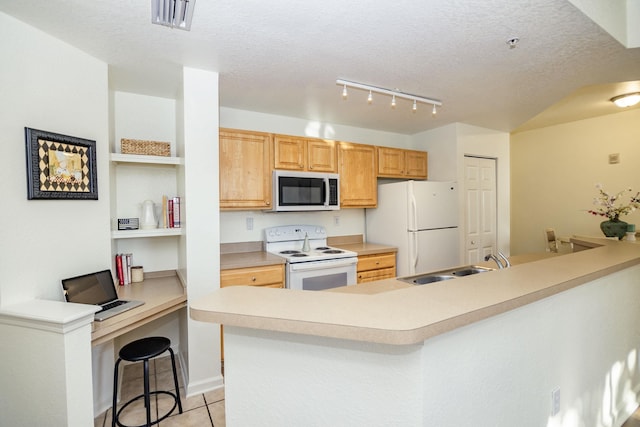 kitchen with a breakfast bar, white appliances, sink, light tile patterned floors, and a textured ceiling