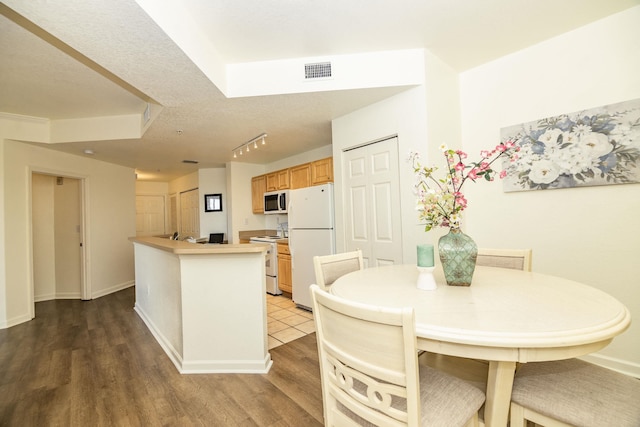 dining room featuring a textured ceiling and hardwood / wood-style flooring