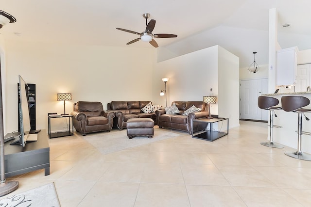 tiled living room with ceiling fan and high vaulted ceiling