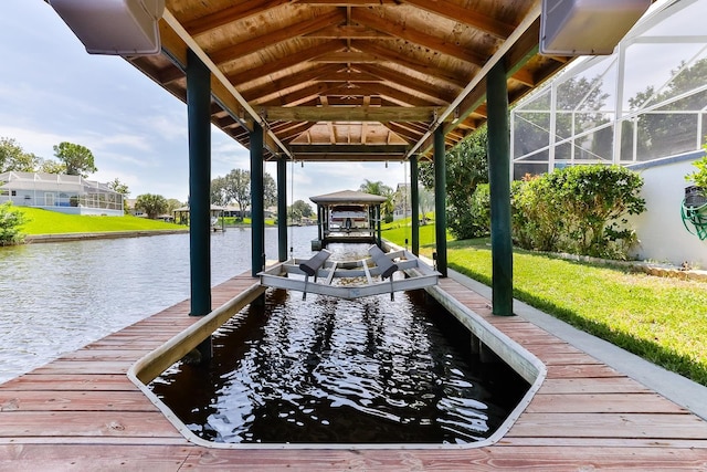 dock area featuring glass enclosure, a water view, and a yard