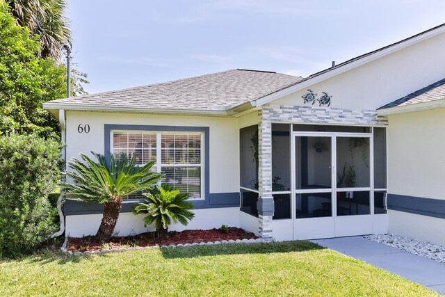 view of home's exterior featuring a lawn and a sunroom