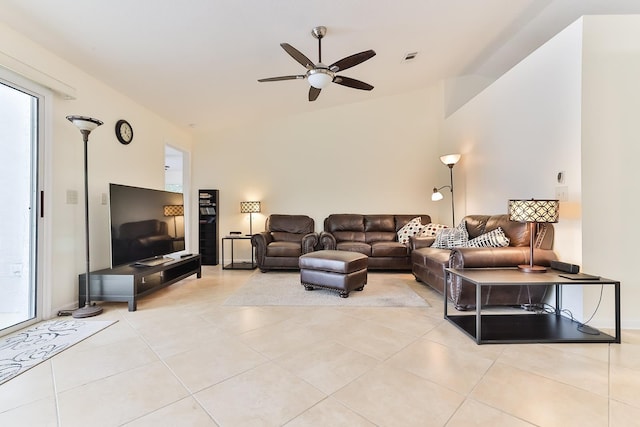 living room featuring ceiling fan, light tile patterned floors, and vaulted ceiling