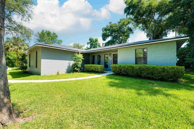 view of front of property featuring brick siding and a front lawn