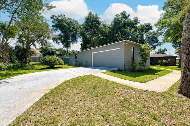 view of front of property featuring brick siding, driveway, a front lawn, and an attached garage