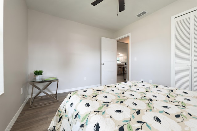 bedroom with a closet, dark wood-type flooring, baseboards, and ceiling fan