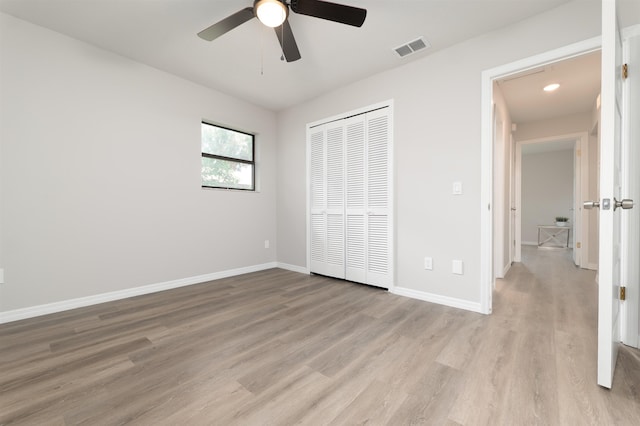 unfurnished bedroom with light wood-type flooring, a closet, baseboards, a ceiling fan, and recessed lighting