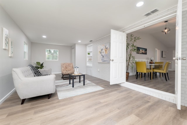 living area featuring baseboards, wood finished floors, recessed lighting, and built in features