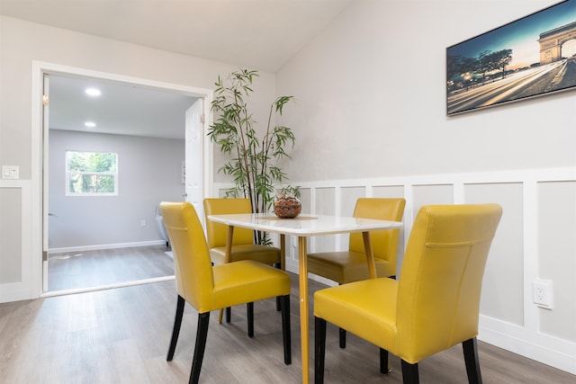 dining room with wood finished floors, vaulted ceiling, recessed lighting, and baseboards