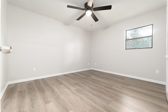 unfurnished room featuring wood finished floors, baseboards, and ceiling fan