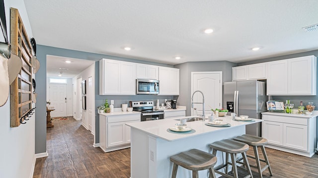 kitchen with stainless steel appliances, a sink, dark wood-style flooring, a breakfast bar area, and recessed lighting